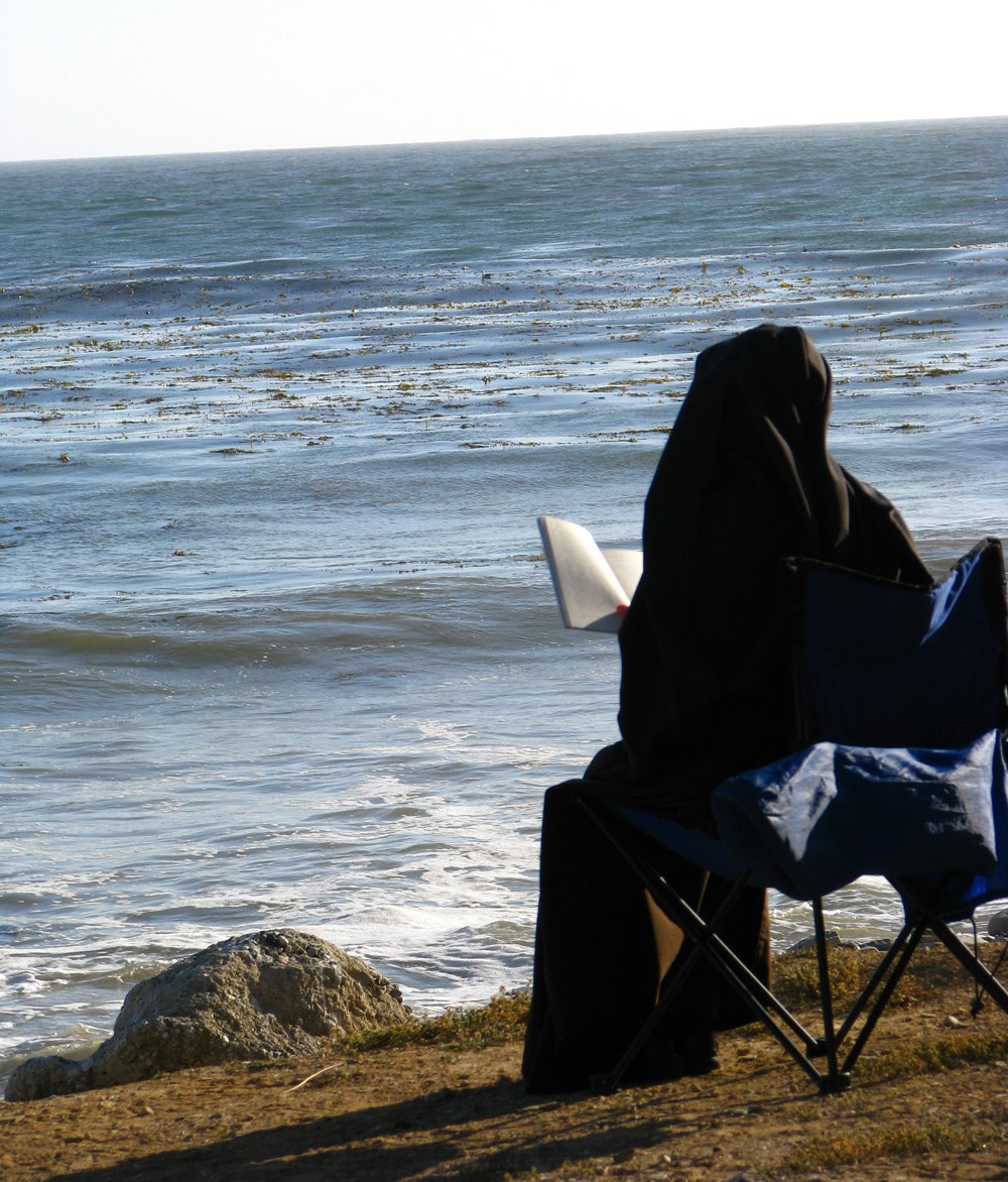 Carmelite Sister Reading on beach