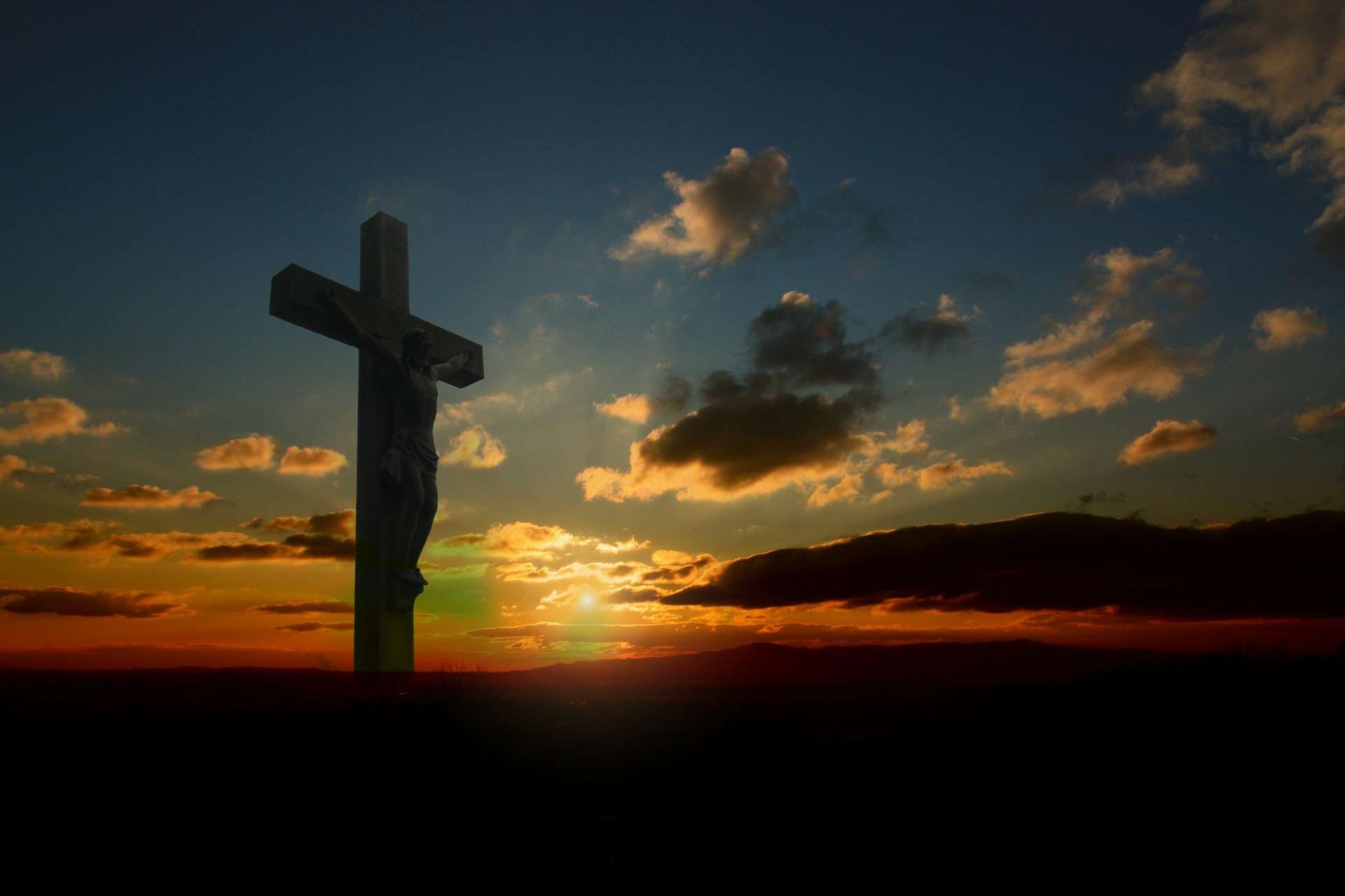 Silhouette of cross, with sunset behind