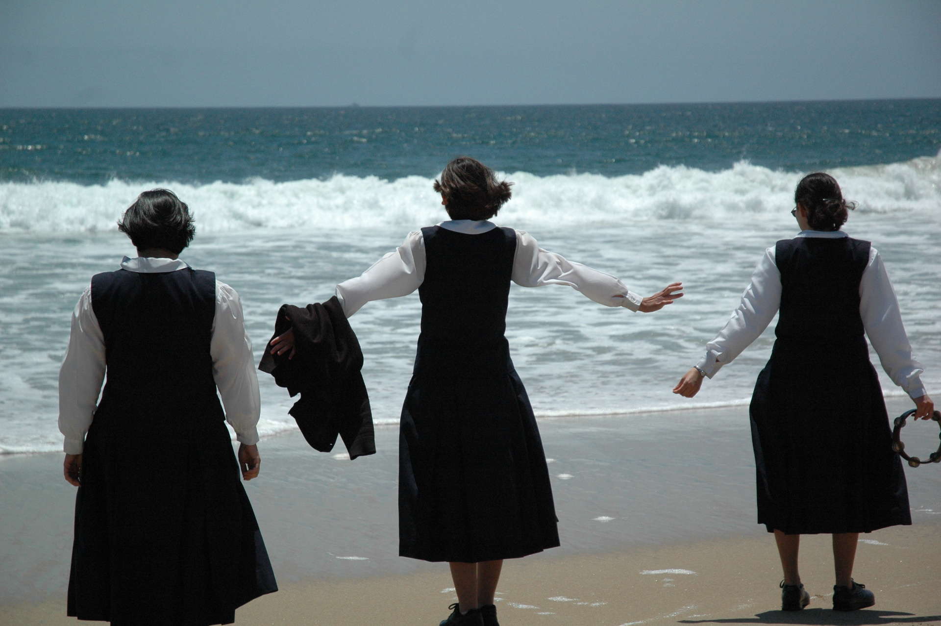 Three postulants looking towards ocean on the beach