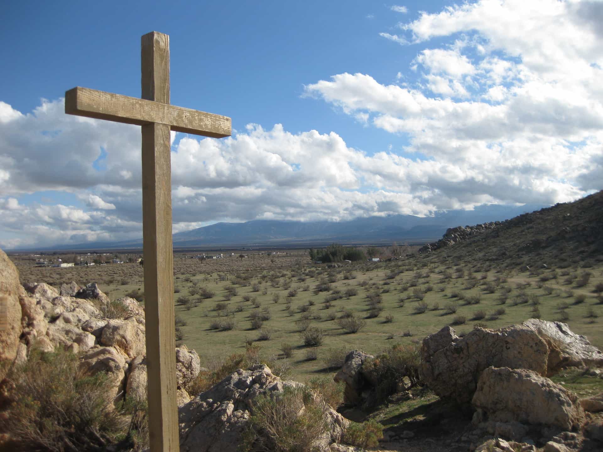 wooden cross in the middle of desert