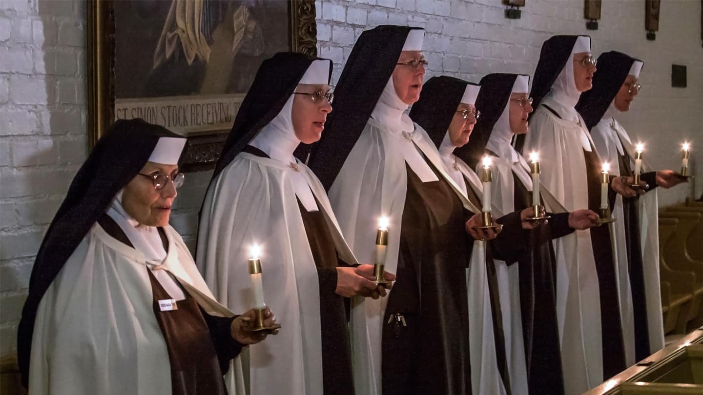 Group of Sisters in line holding candles and singing in Chapel